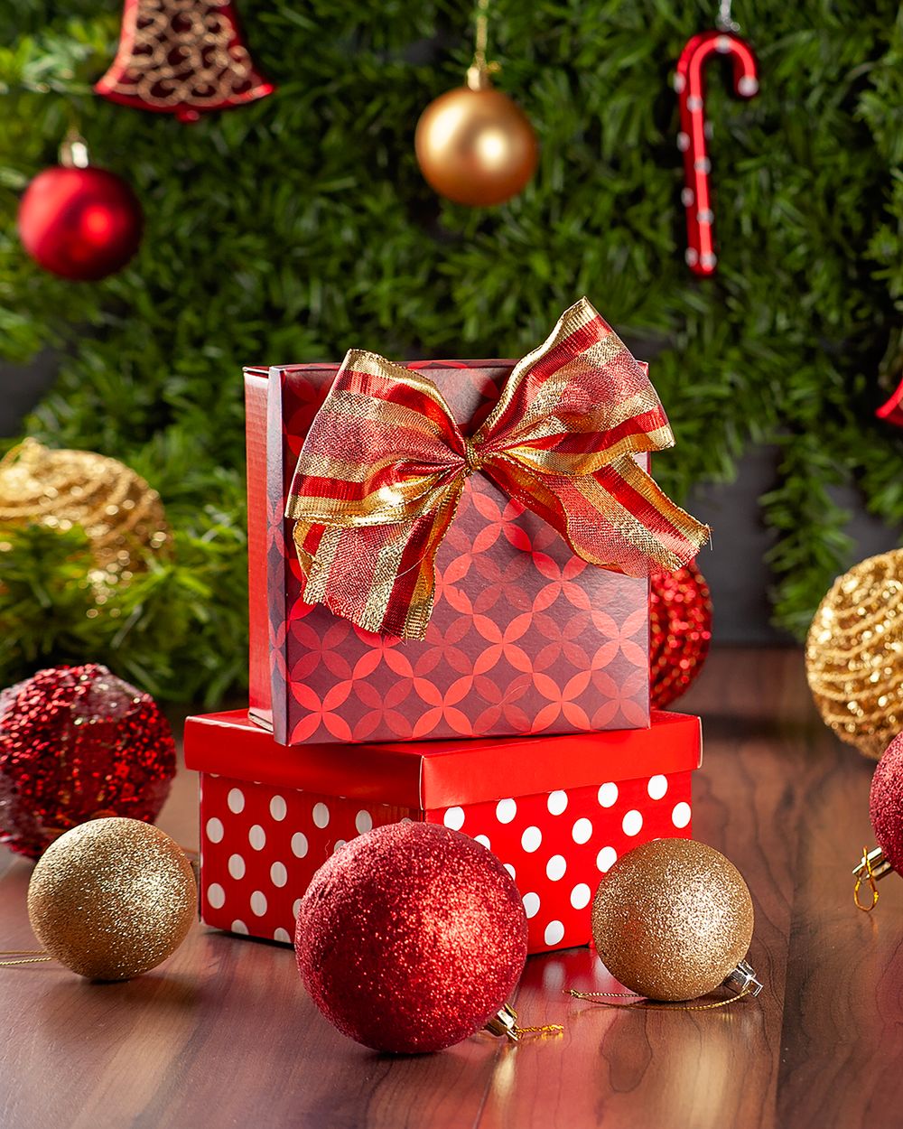 Cadeaux rouges et dorés au pied d’un sapin de Noël